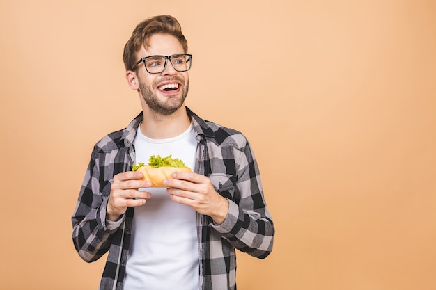 Jeune homme tenant un morceau de sandwich