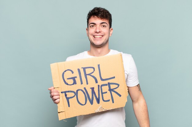 Jeune homme tenant une pancarte avec texte: Girl power. Concept de féminisme