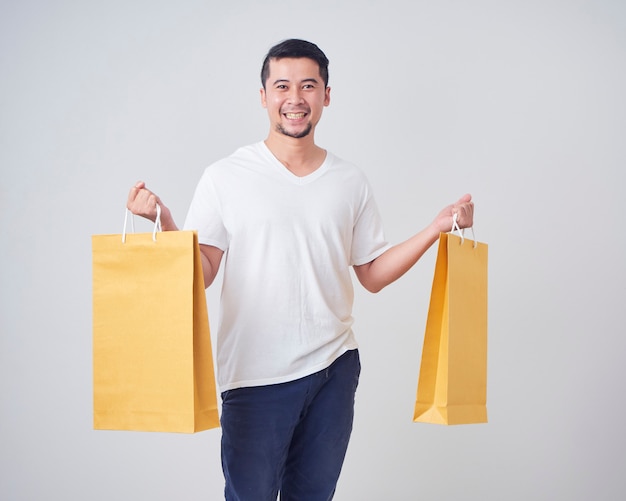 Jeune homme tenant des sacs à provisions.