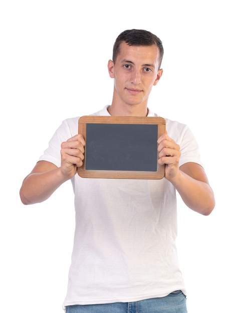 Jeune homme tenant un tableau noir pour écrire dessus sur un mur blanc