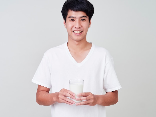 Jeune homme tenant un verre de lait frais.