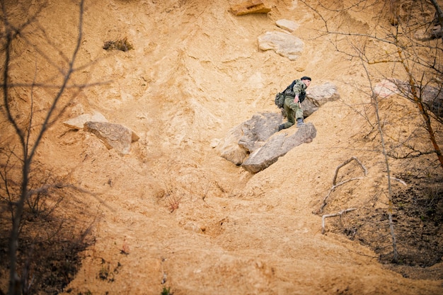 jeune homme en tenue de camouflage monte