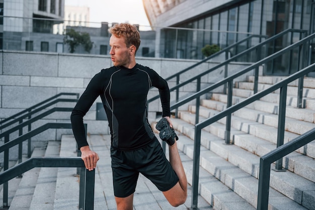 Jeune homme en tenue sportive s'entraîne à l'extérieur pendant la journée