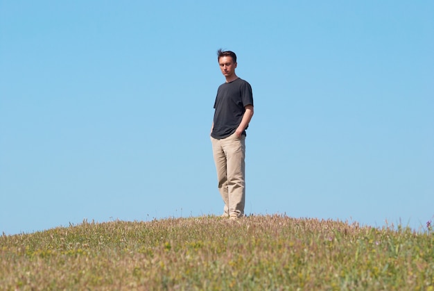 Jeune homme sur le terrain avec un ciel bleu