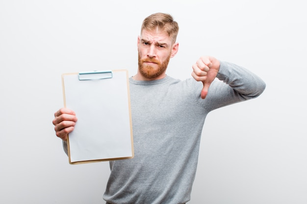 Jeune homme à la tête rouge montrant un document