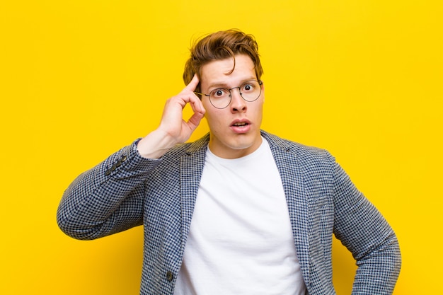 Jeune homme à tête rouge semblant surpris, bouche bée, choqué, réalisant une nouvelle pensée