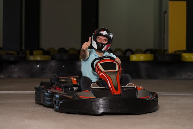 Jeune homme tient une course de karting de vitesse de coupe