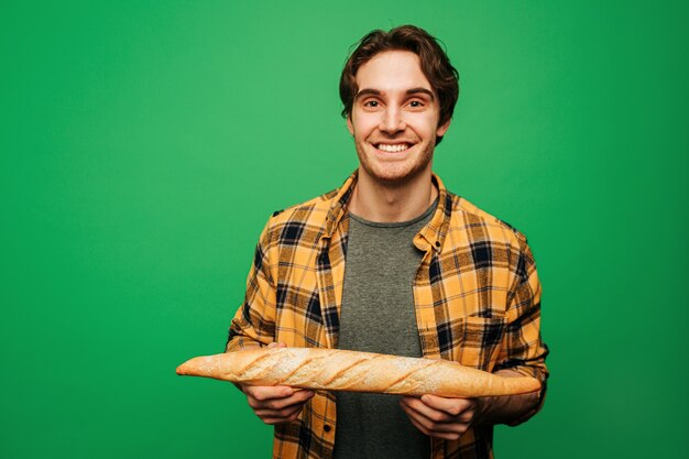 Photo jeune homme tient du pain et se sent bien