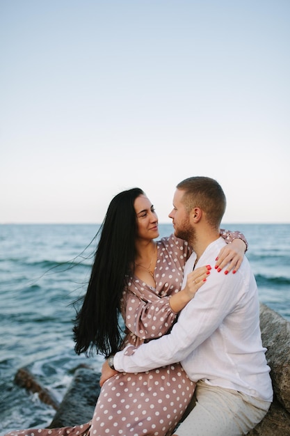 Jeune homme tient sur les mains belle jeune femme Couple passe du temps au bord de la mer Mer d'été bonne humeur