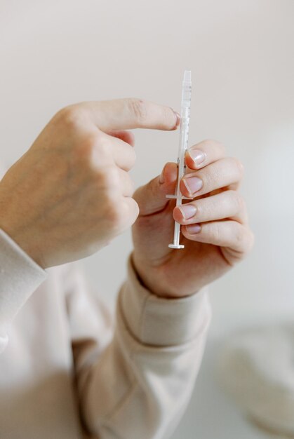Un jeune homme tient un médicament dans une seringue dans ses mains