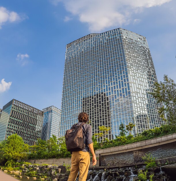 Photo jeune homme touriste dans le ruisseau cheonggyecheon à séoul corée le ruisseau cheonggyecheon est le résultat d'un