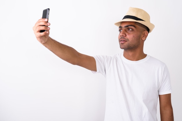 Jeune homme touriste indien portant un chapeau sur blanc