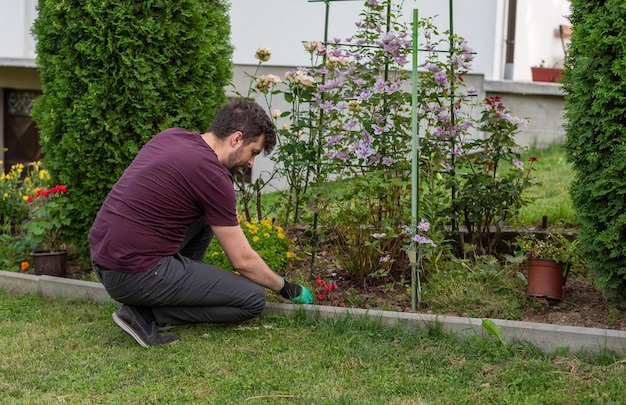 Un jeune homme travaillant dans un jardin de printemps