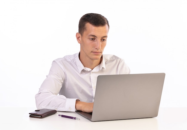 Jeune homme travaillant avec un ordinateur sur fond blanc