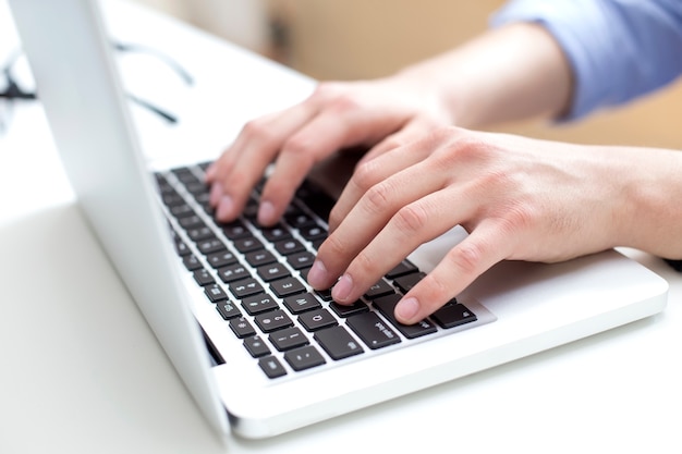 Jeune homme travaillant sur un ordinateur portable dans son bureau