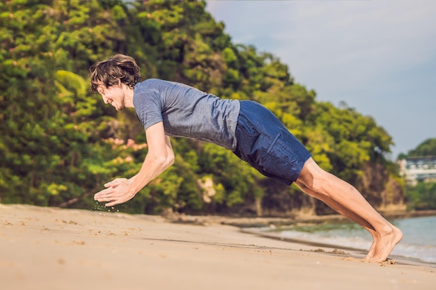 Jeune homme travaillant sur la plage, homme sportif faisant des exercices