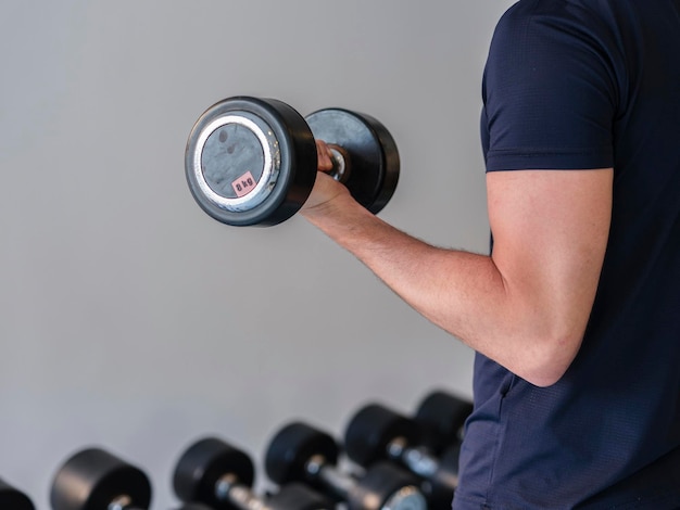 Un jeune homme travaillant sur des poids à la salle de gym