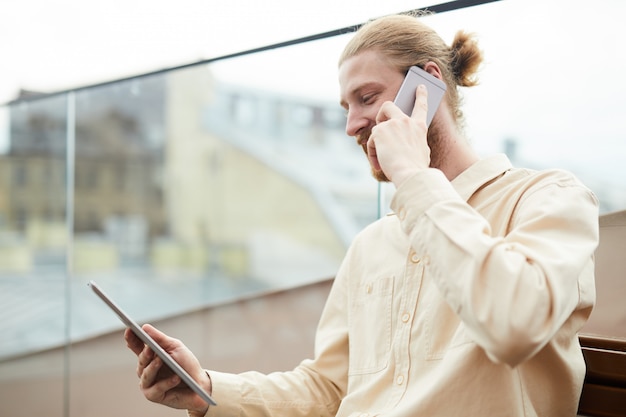 Jeune homme travaillant sur téléphone mobile