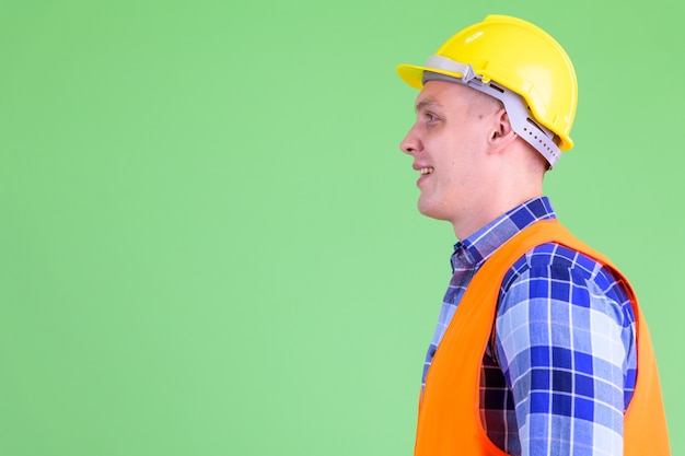 Jeune homme travailleur de la construction contre le mur végétal