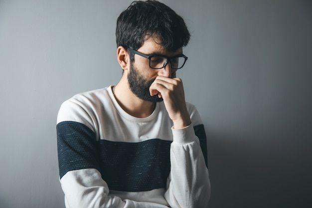 Jeune homme triste dans une pièce sombre