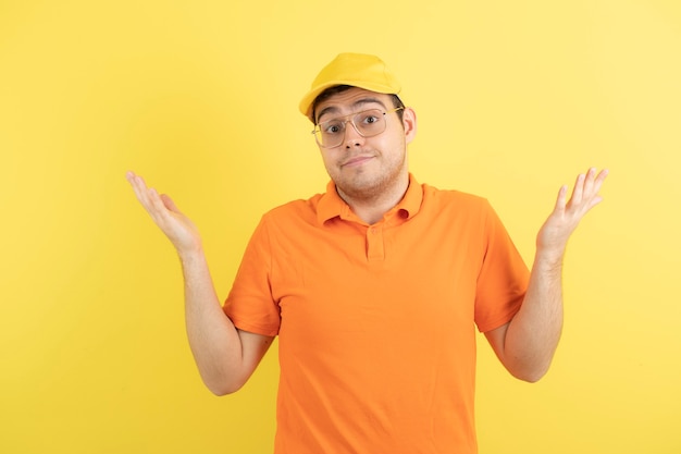 jeune homme en uniforme orange debout et posant.