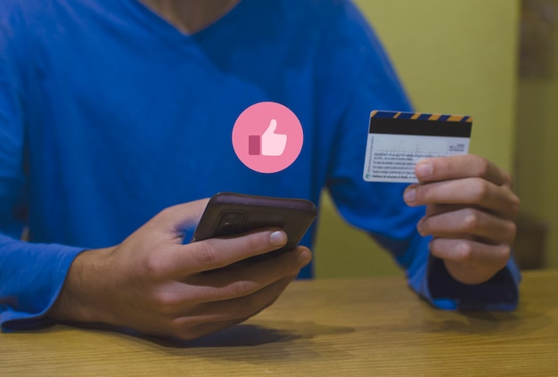 Jeune homme utilisant une carte de crédit avec sa carte de crédit phosing avec son concept de consommateur de téléphone