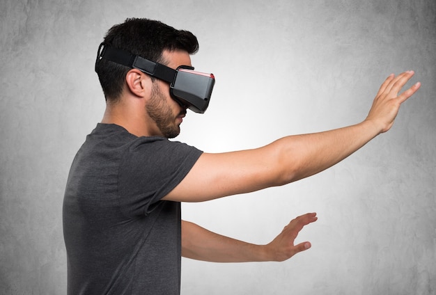 Jeune homme utilisant un casque VR et connaissant la réalité virtuelle