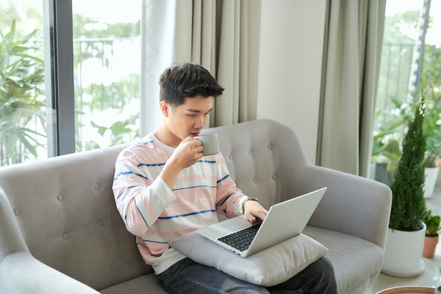 Jeune homme utilisant un ordinateur portable à la maison