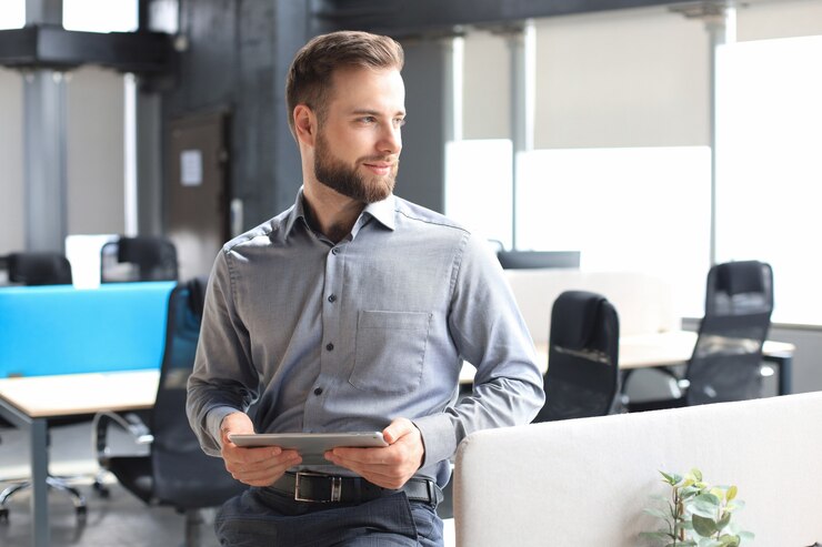 Photo jeune homme utilisant sa tablette au bureau.