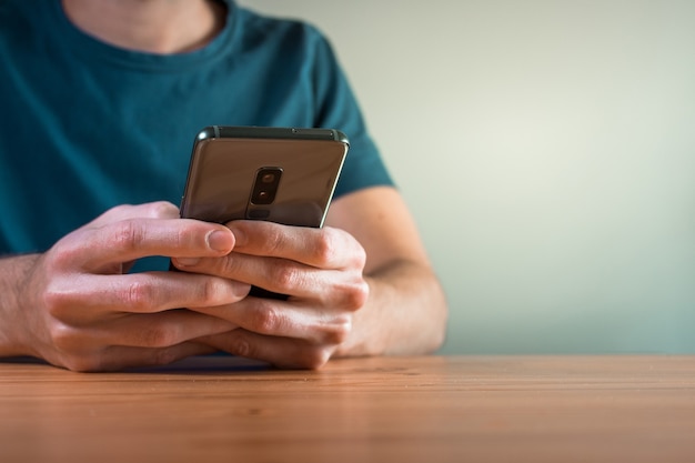 Jeune homme utilisant son smartphone et textos