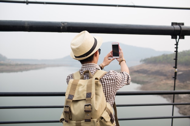 Jeune homme, utilisation, téléphone, et, selfie, sur, pont