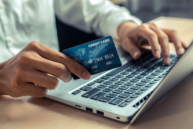 Jeune homme utilise une carte de crédit pour les achats en ligne