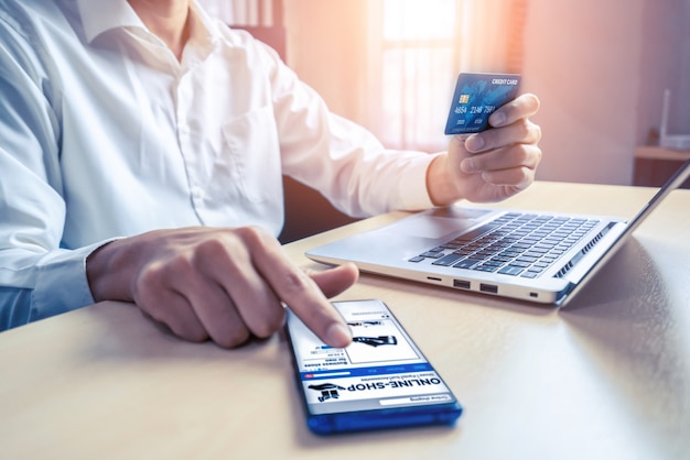 Jeune homme utilise une carte de crédit pour faire des achats en ligne