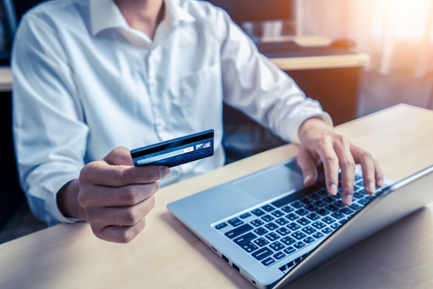Jeune homme utilise une carte de crédit pour faire des achats en ligne