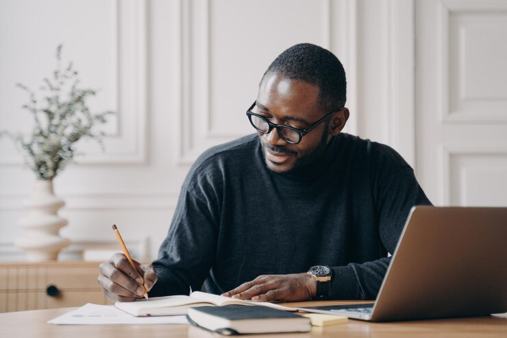 Photo un jeune homme utilise un ordinateur portable au bureau.