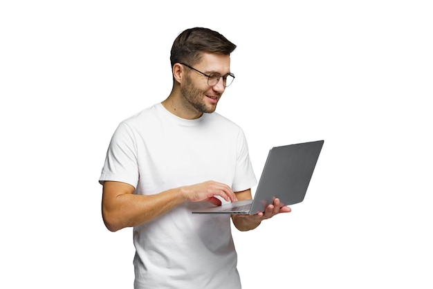 Un jeune homme utilise un ordinateur portable tout en souriant lors d'une activité en ligne à la maison