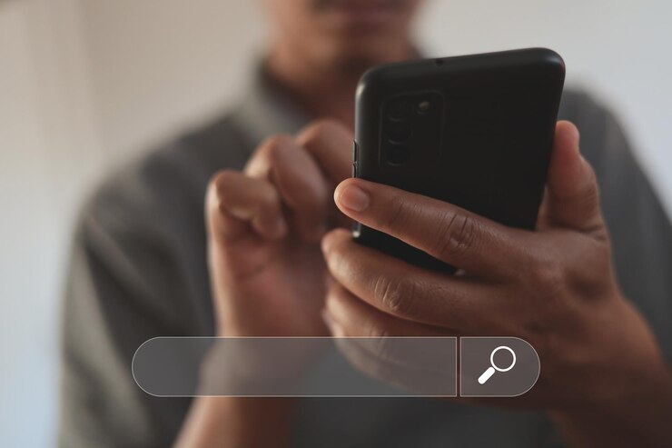 Un jeune homme utilise un smartphone pour rechercher des informations sur Internet.