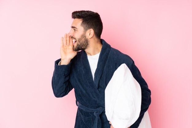 Jeune homme va dormir isolé sur mur rose criant avec la bouche grande ouverte