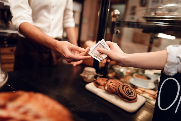 Jeune homme vendant du pain à un client dans une boulangerie