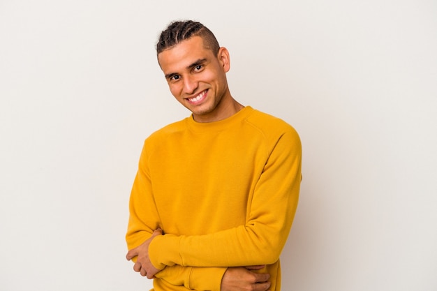 Jeune homme vénézuélien isolé sur fond blanc malheureux à la recherche à huis clos avec une expression sarcastique.