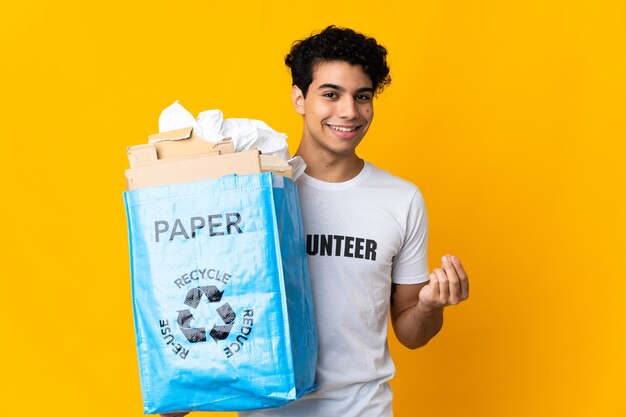 Jeune homme vénézuélien tenant un sac de recyclage plein de papier pour recycler en faisant de l'argent geste