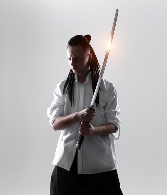 Photo un jeune homme vêtu de samouraï debout sur un fond blanc