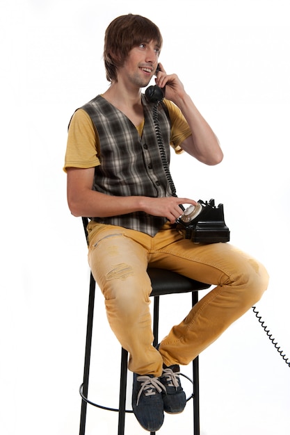 Un jeune homme avec un vieux téléphone dans les mains