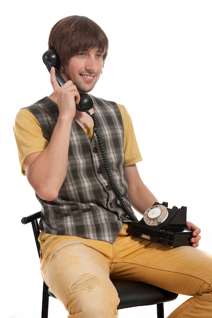 Un jeune homme avec un vieux téléphone dans les mains