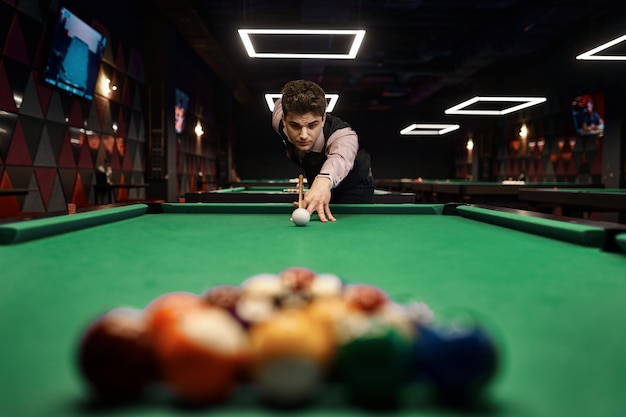 Jeune homme visant avec queue de billard