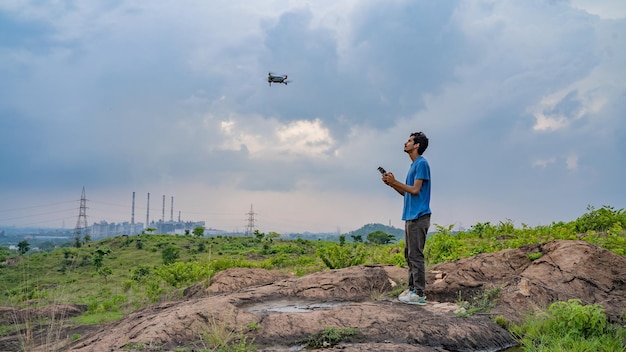 Jeune homme volant drone véhicule aérien sans pilote photographe cinéaste ou concept de créateur de contenu