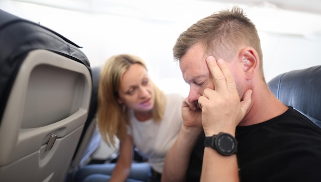 Photo un jeune homme vole dans un avion et tient une tête douloureuse.