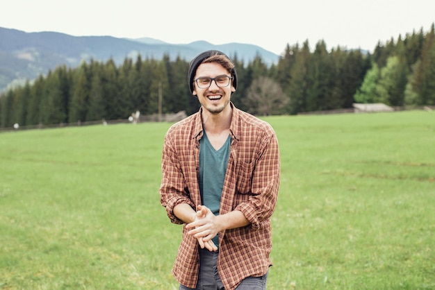 Un jeune homme voyage avec un appareil photo dans les montagnes