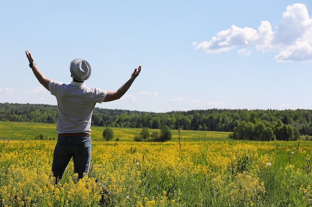 Le jeune homme voyage avec un sac à dos un jour d'été dehors