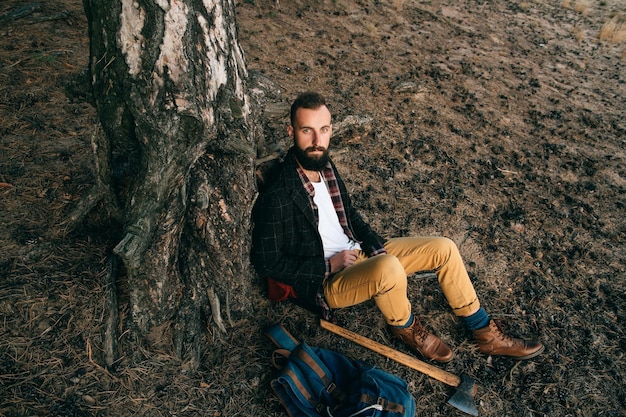 Un jeune homme voyage avec un sac à dos à travers la forêt